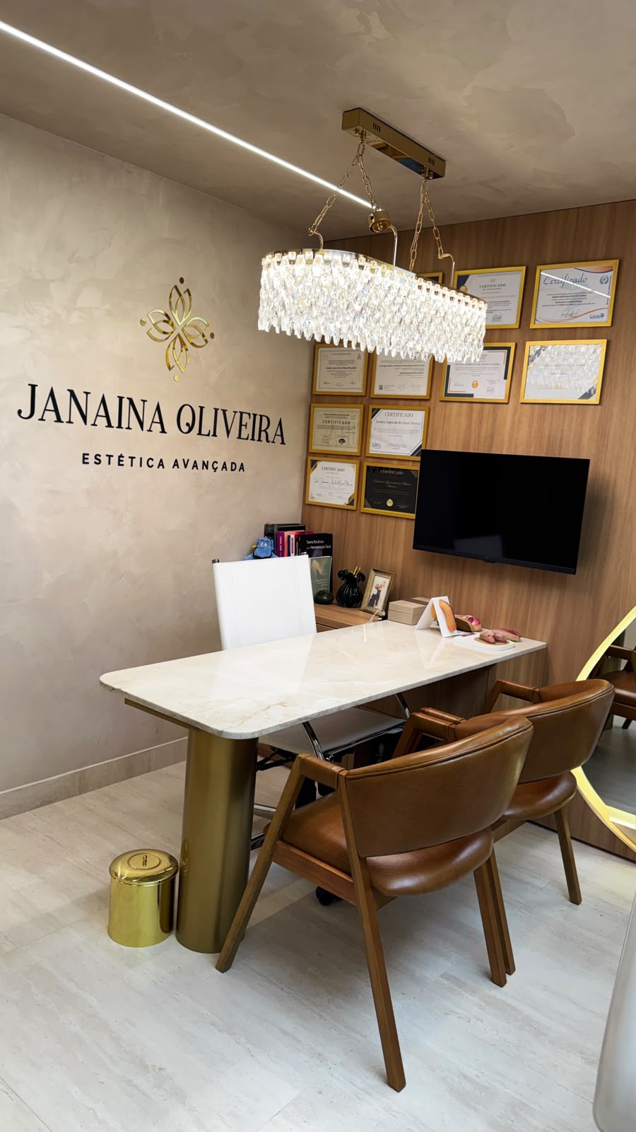 Consultório da Dra. Janaina Oliveira com a parede assinatura e lustre de cristais